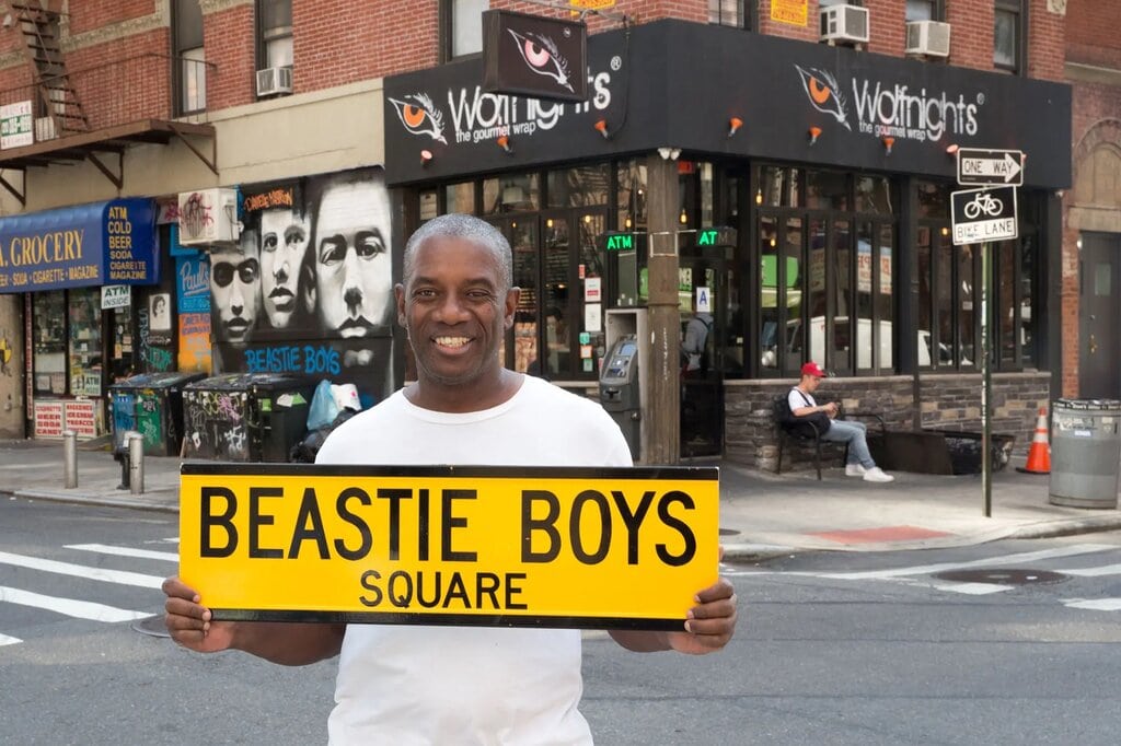 A person standing at the corner of Rivington and Ludlow streets advocating that it be renamed Beastie Boys Square.
