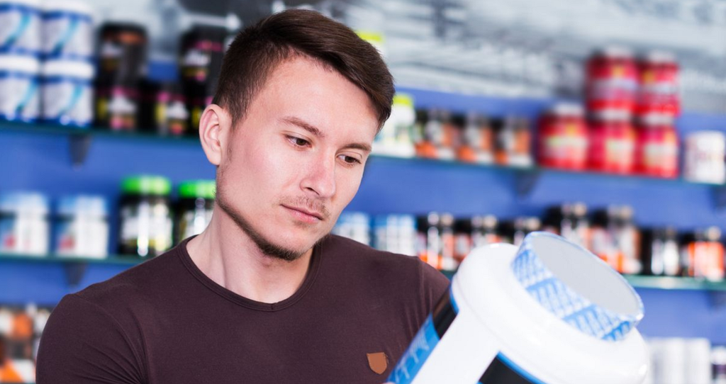 A person looking at a jug of protein powder