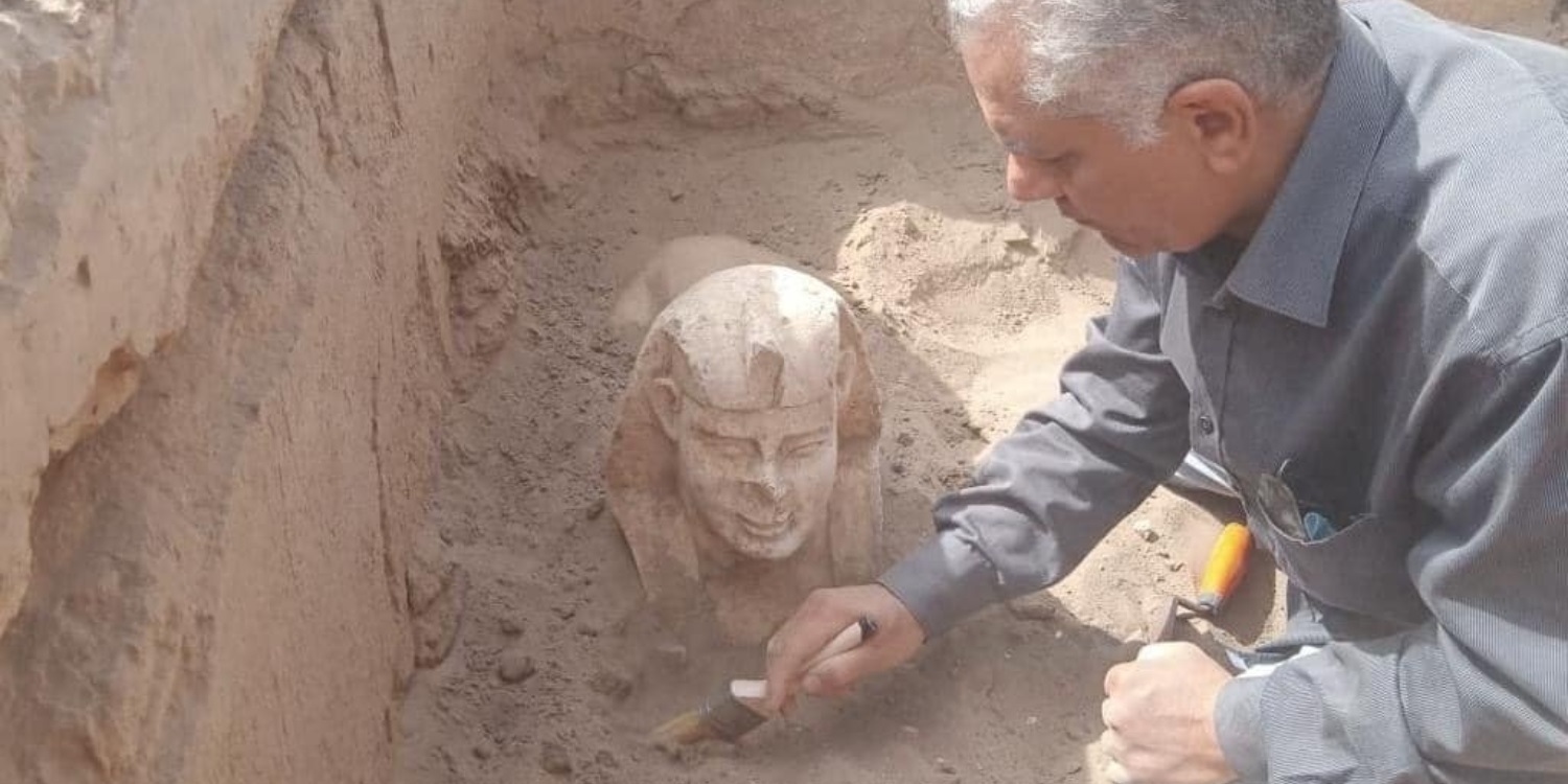 An archaeologist clearing the newly discovered smiling sphinx statue